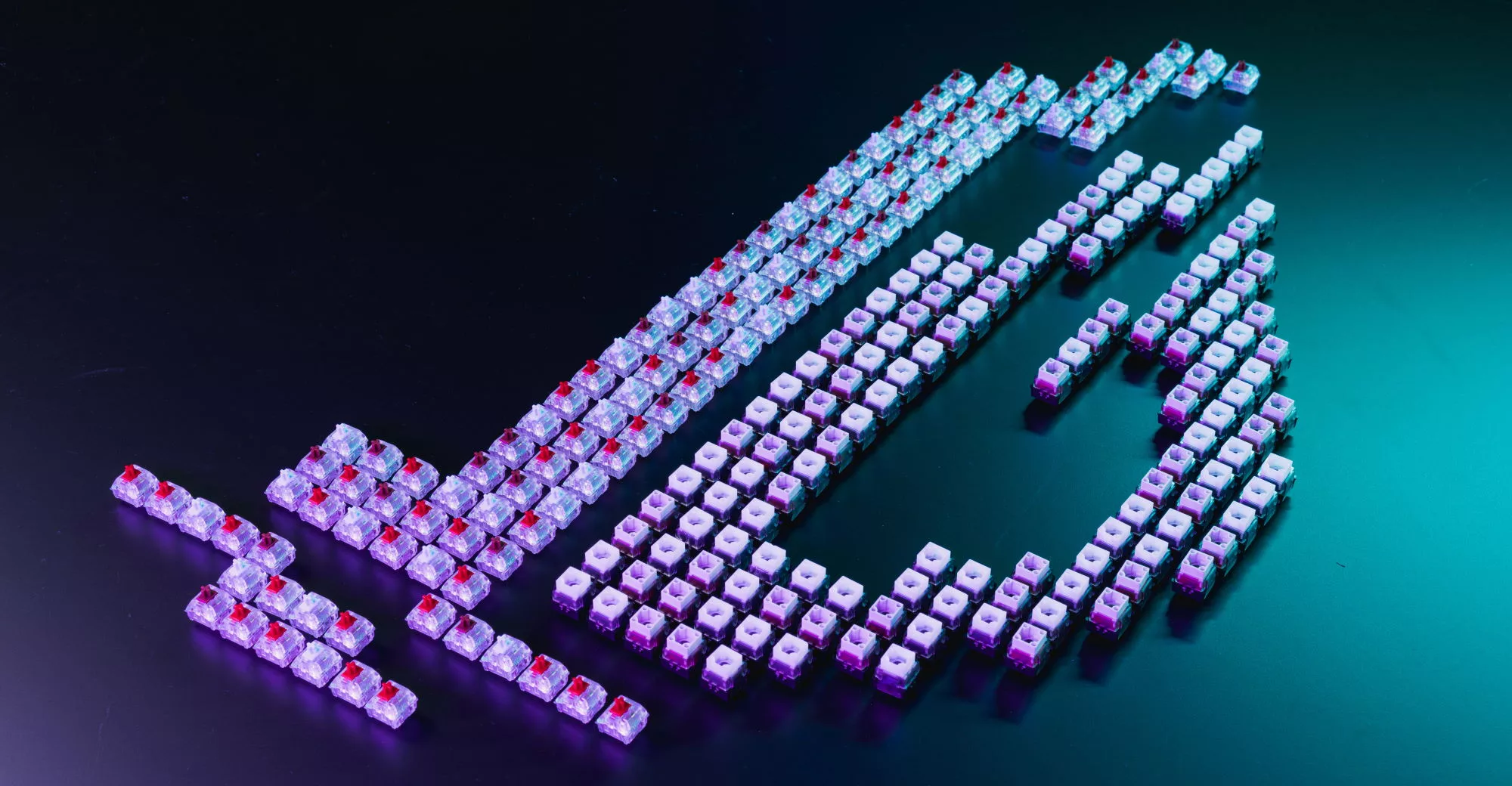 One or two hundred key caps and switches arranged on a table in the shape of the ROG eye logo.