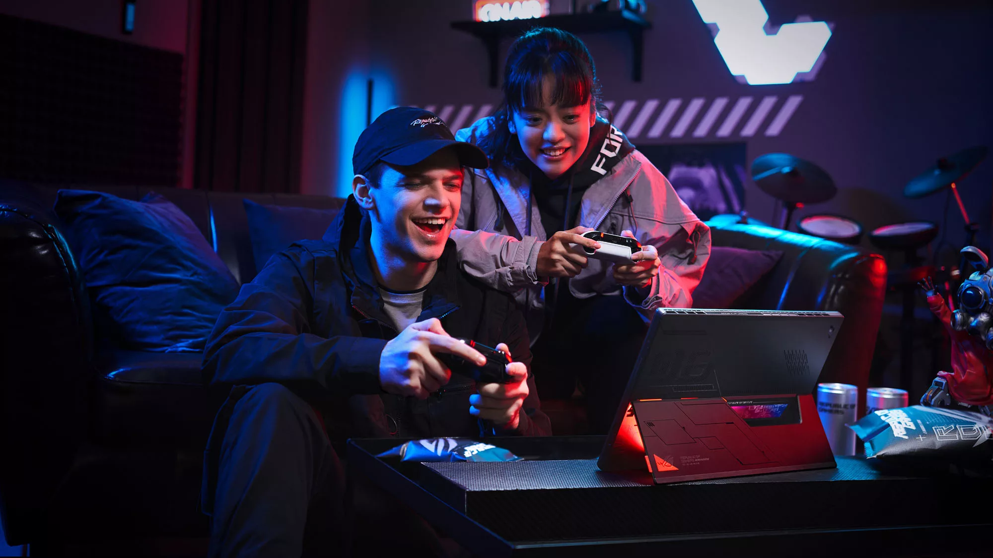 Two gamers, each sitting on a couch and holding a gamepad, enjoying a game together on the Flow Z13.