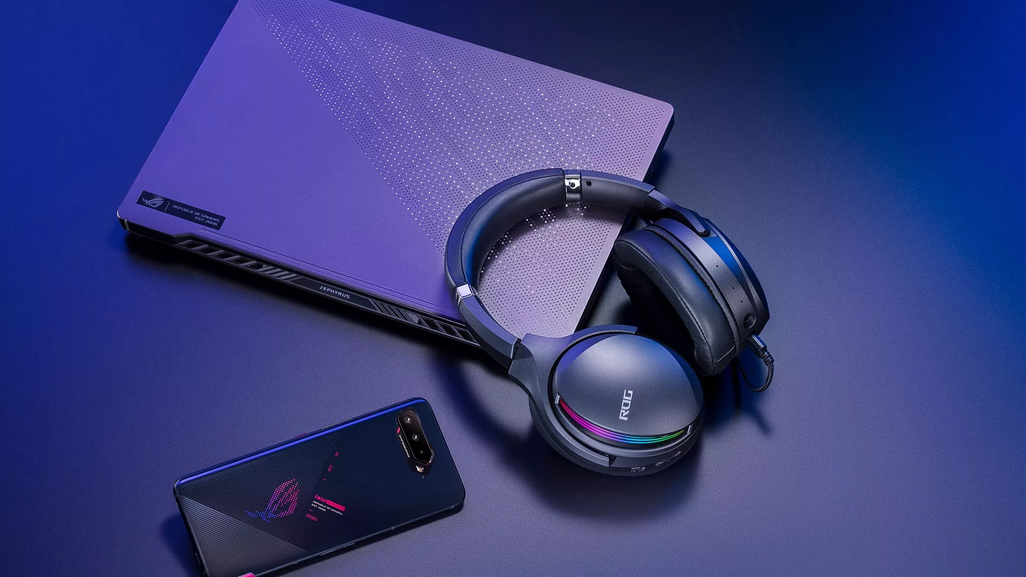 Zephyrus G14, ROG Phone 5, and an ROG Fusion II headset on a table.