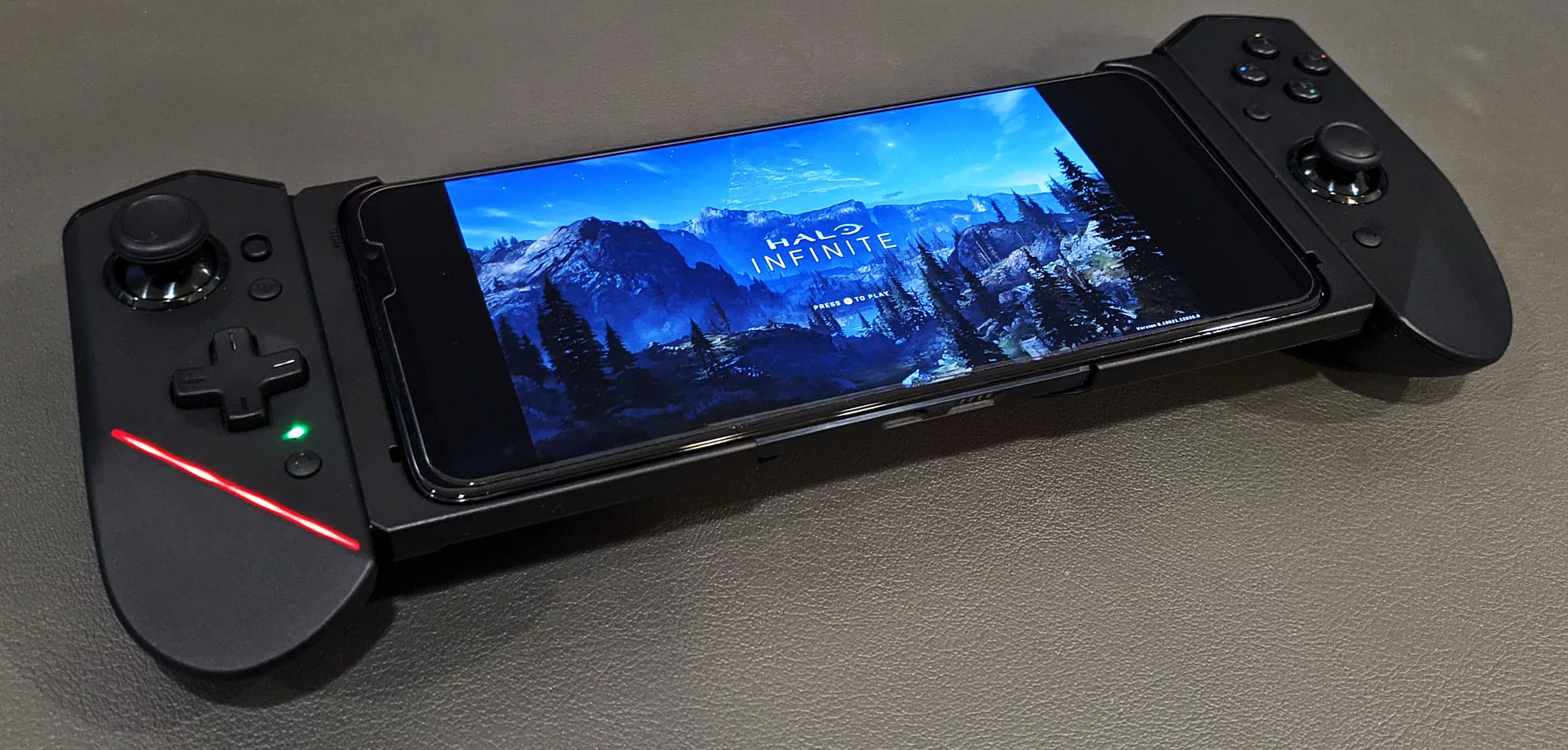 An ROG Phone 5s connected to the ROG Kunai gamepad, showing the Halo Infinite title screen.