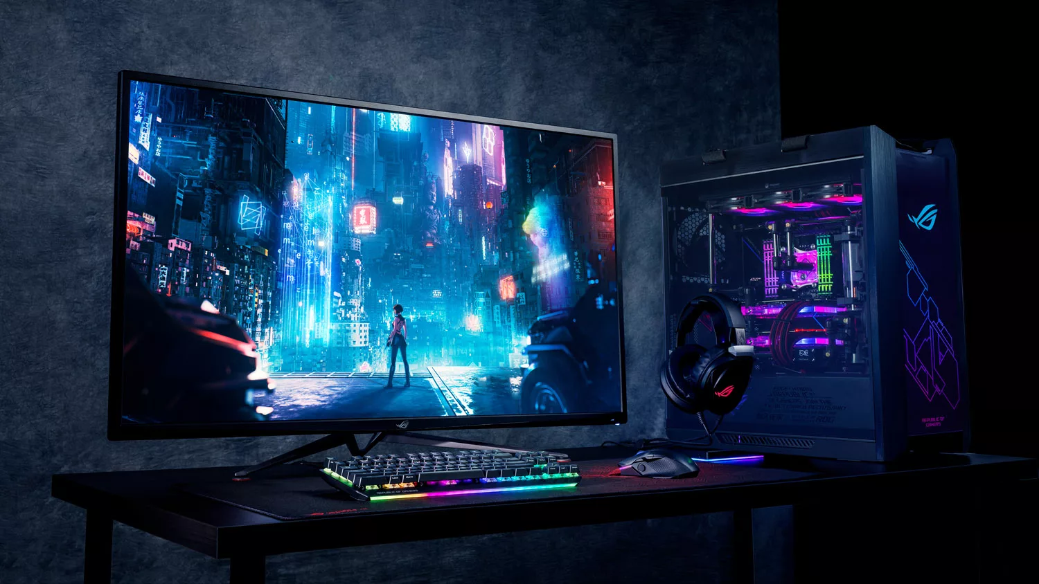 A photo of a gaming setup, with a desktop PC, gaming headset, mouse and keyboard, and large monitor on a desk.