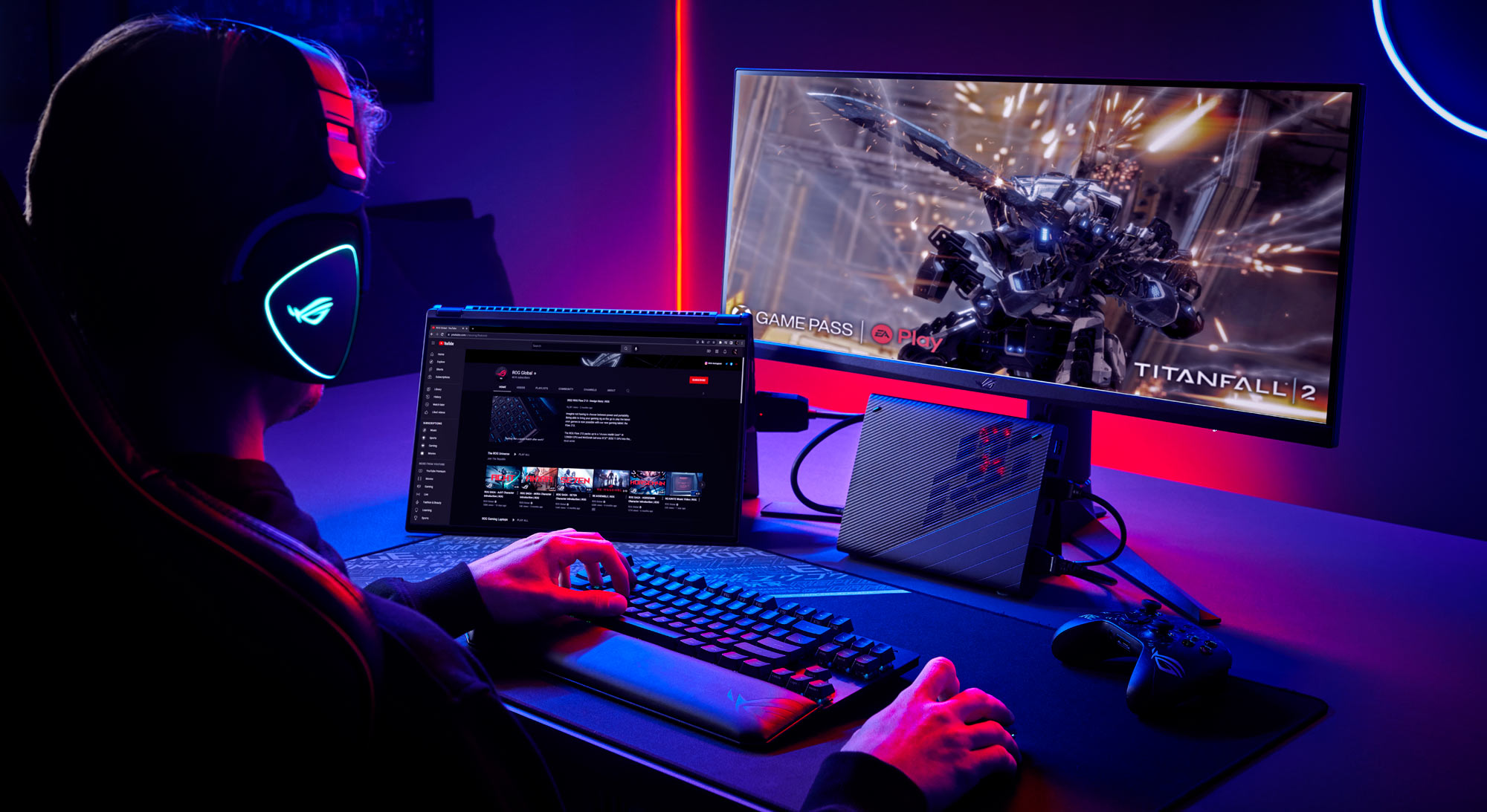 An image of a man playing video games at a desk, with the ROG Flow X16 laptop hooked up to a monitor, mouse, keyboard, and XG mobile..