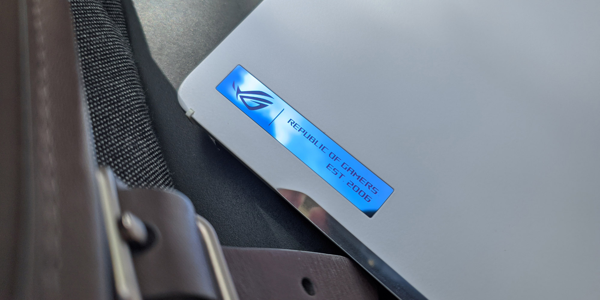 A close-up photo of the Zephyrus G14's blue metal badge with the ROG logo inscribed on it.