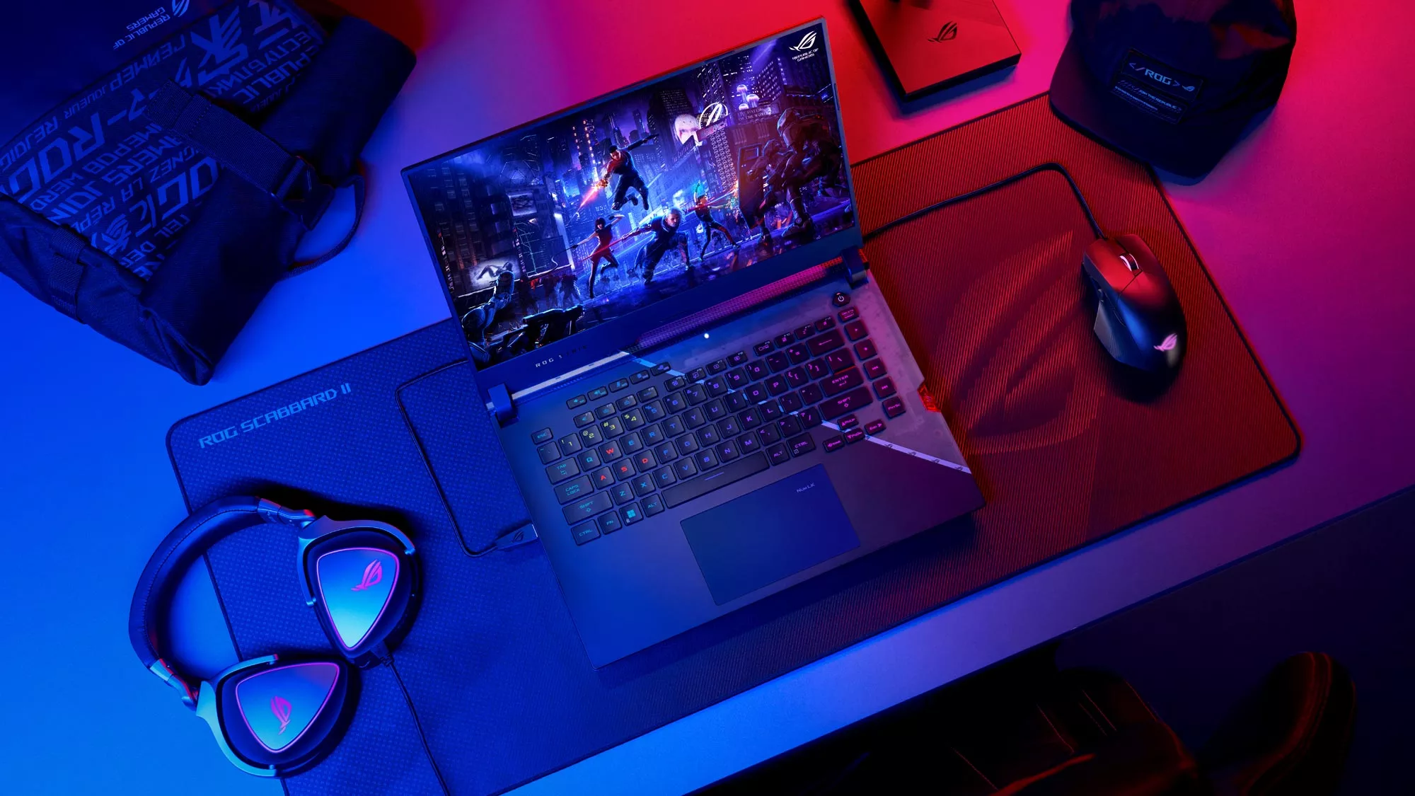 A photo of the ROG Strix SCAR laptop on a table next to a mouse and gaming headset.