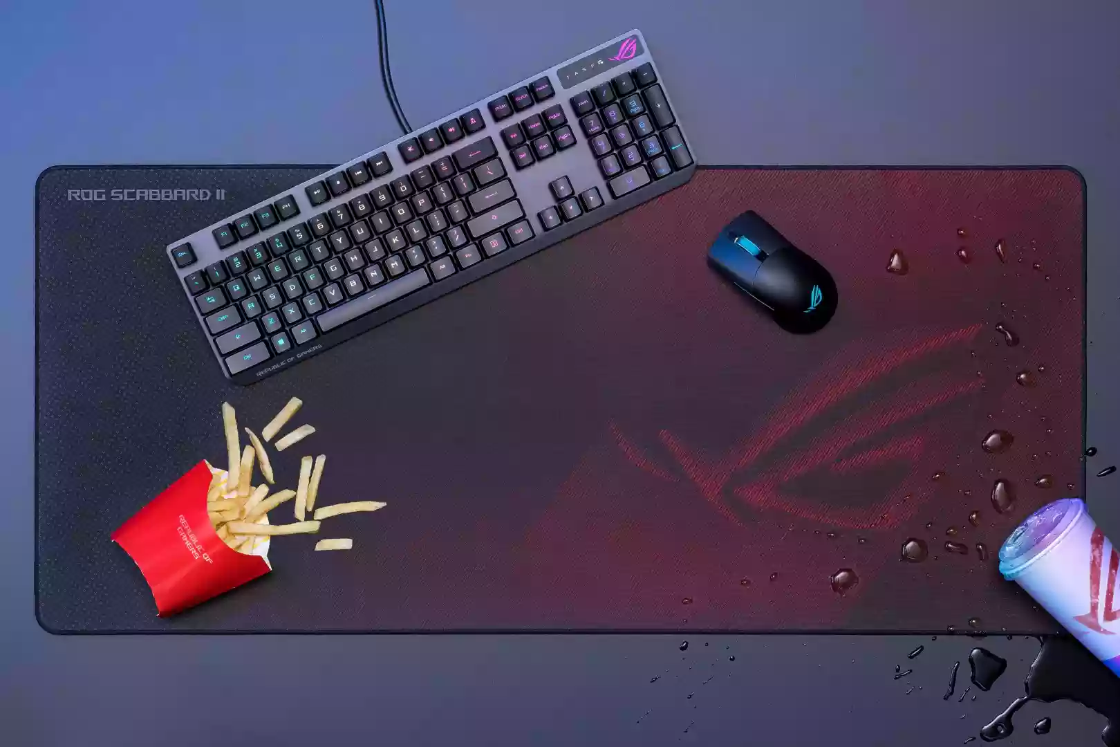 Gaming-Mauspad ROG Scabbard mit Tastatur. Maus und Schmutz durch Pommes und Cola