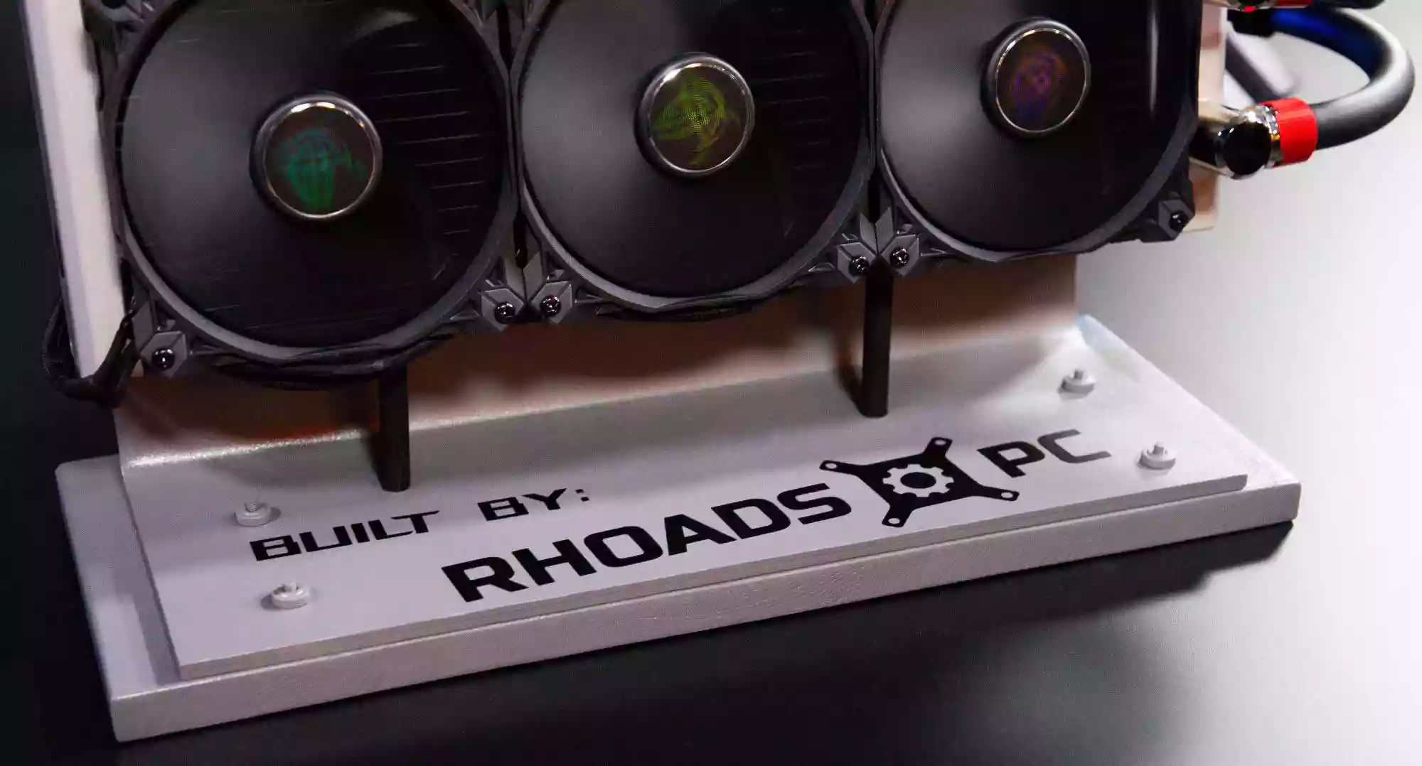 The custom base for the 360mm cooling loop with the text Built by RhoadsPC on it
