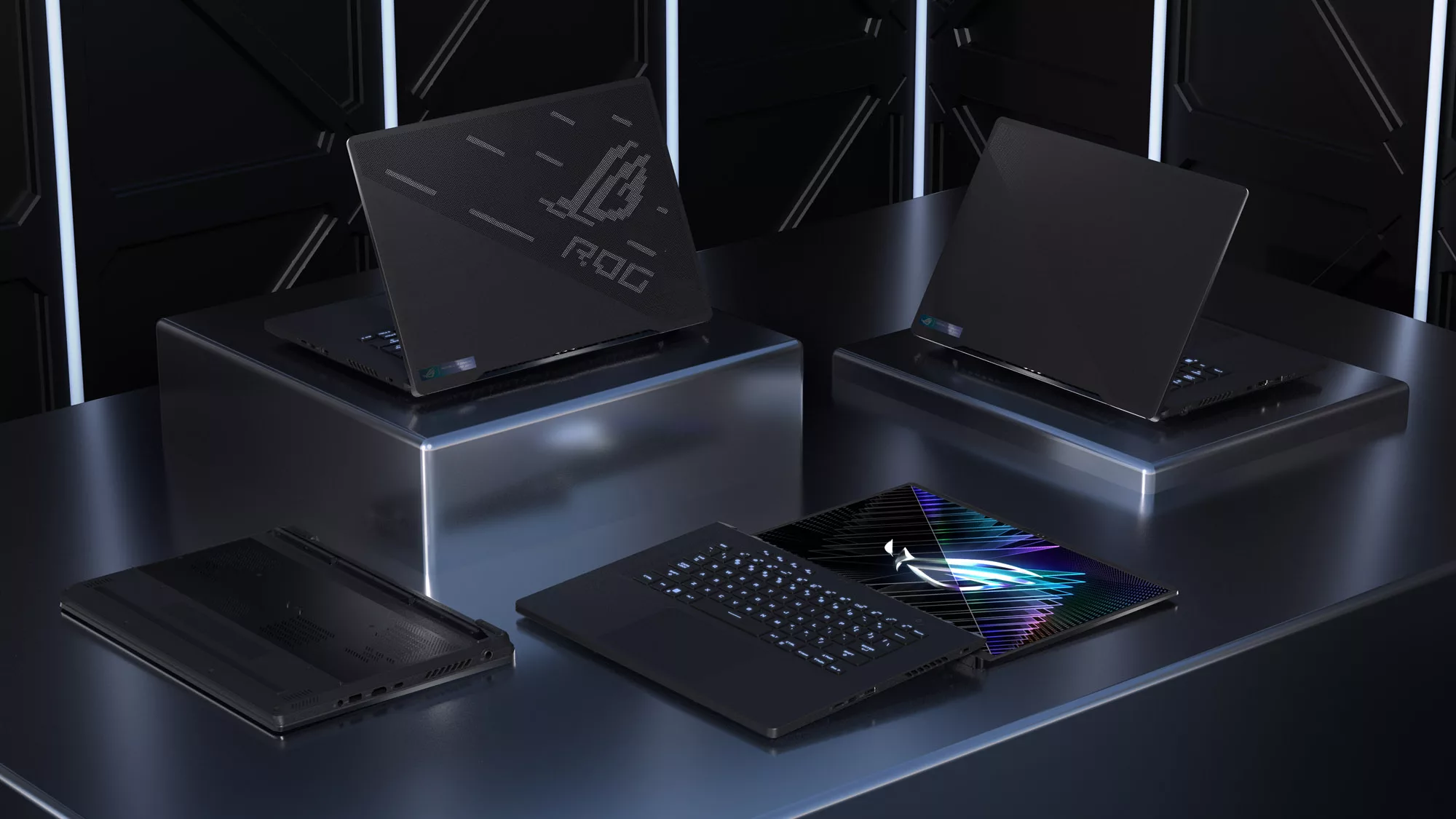 Four ROG Zephyrus M16’s, arranged on three pillars of differing heights, with the lid closed, half opened, and fully opened.