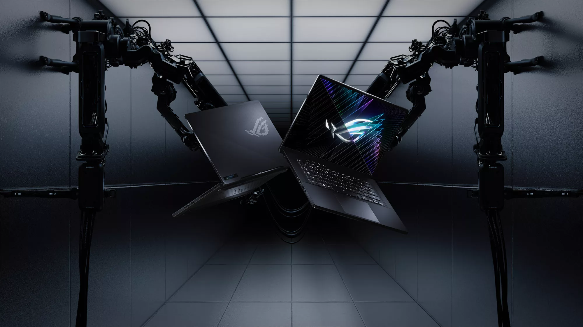 A front and rear view of the ROG Zephyrus M16 laptops, held by mechanical arms, with the ROG logo visible on screen.