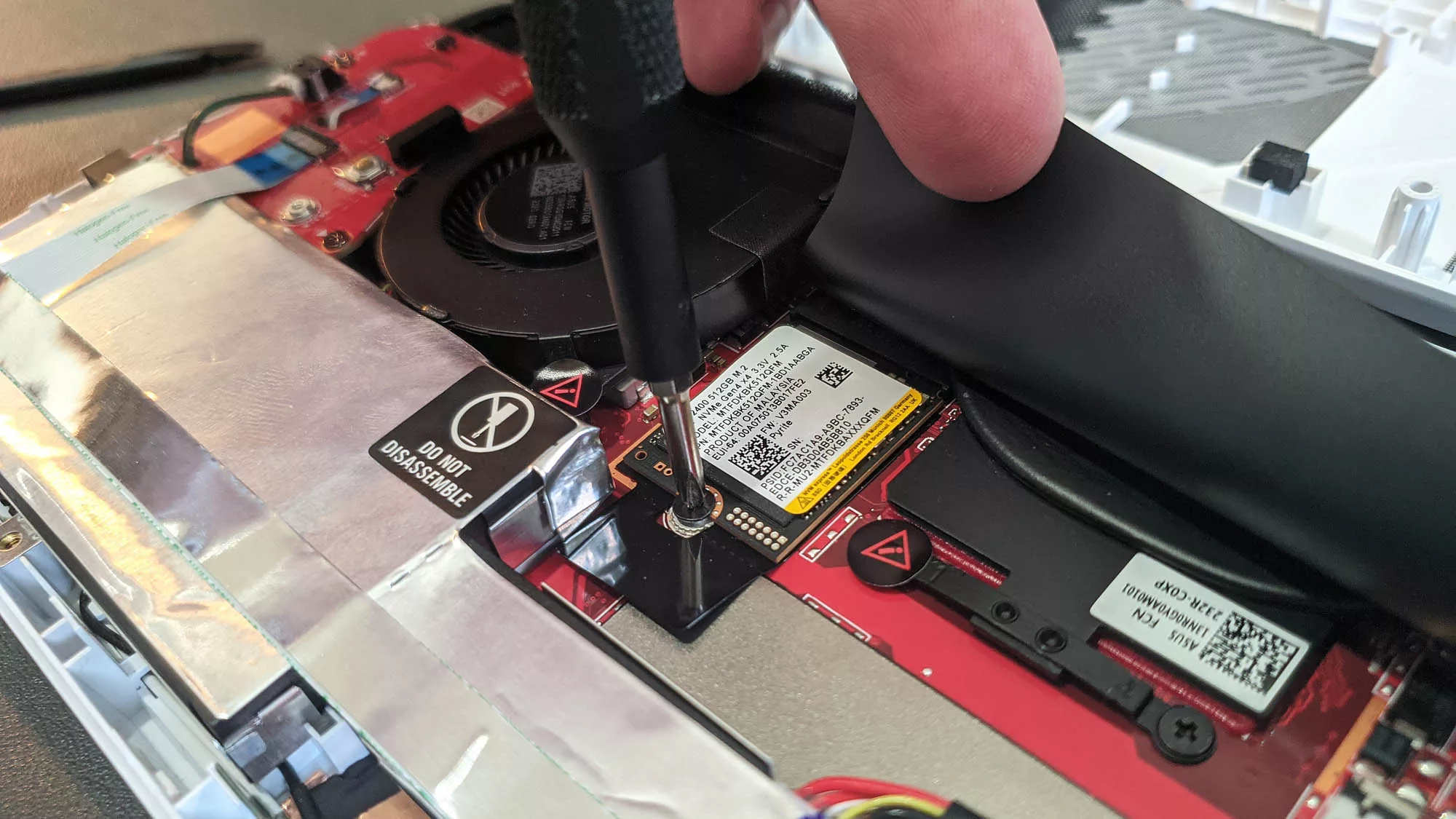 A screwdriver inserted into the M.2 screw of the ROG Ally's SSD.